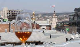 Tblisi rooftops with a glass of orange wine