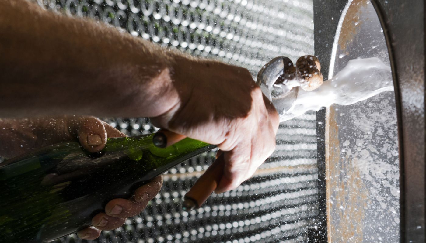 Bottle of sparkling wine being disgorged by hand at Gramona