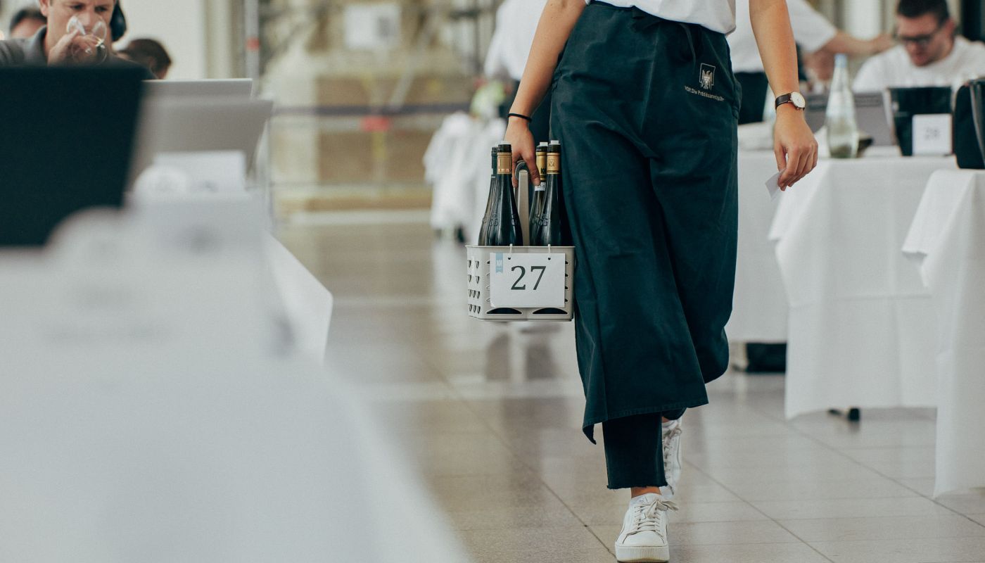 server delivering bottles to a taster's table at Wiesbaden 2022