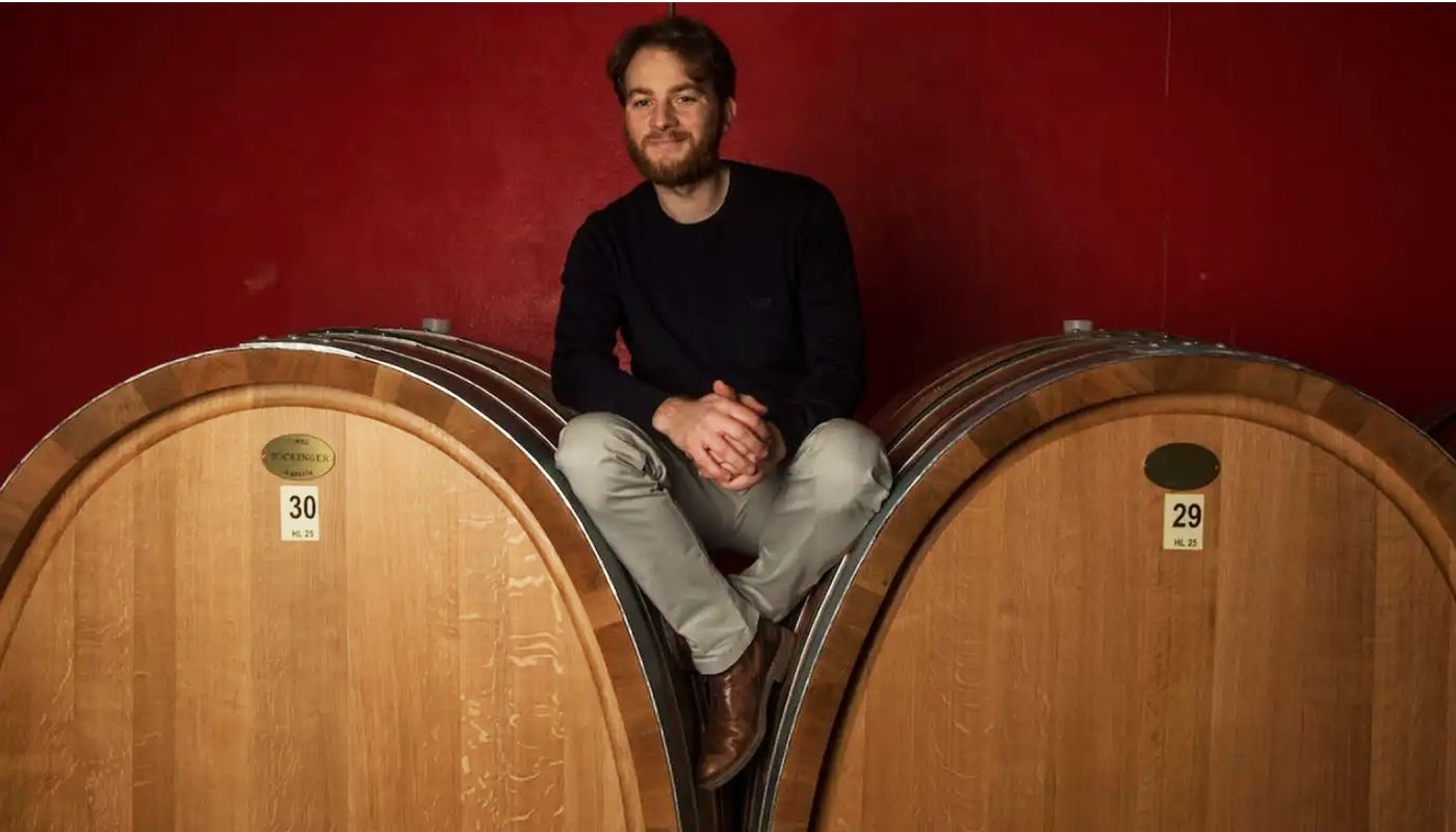 Diego Conterno sits on large botti in his cellar