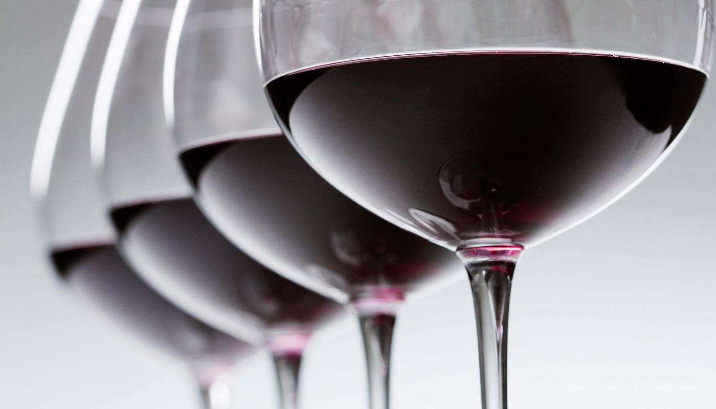 Red wine glasses lined up for a tasting.