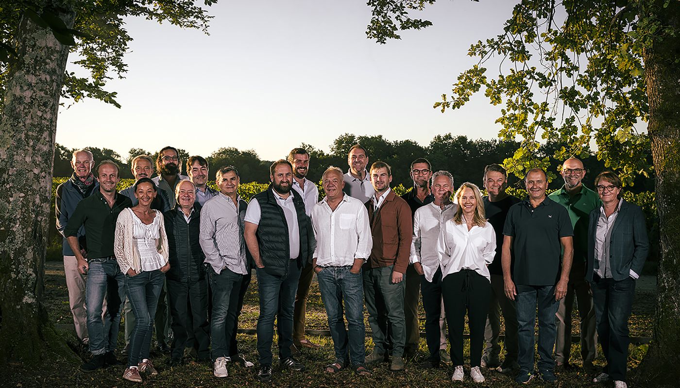 The members of the Castillon Caracteres standing in front of a vineyard