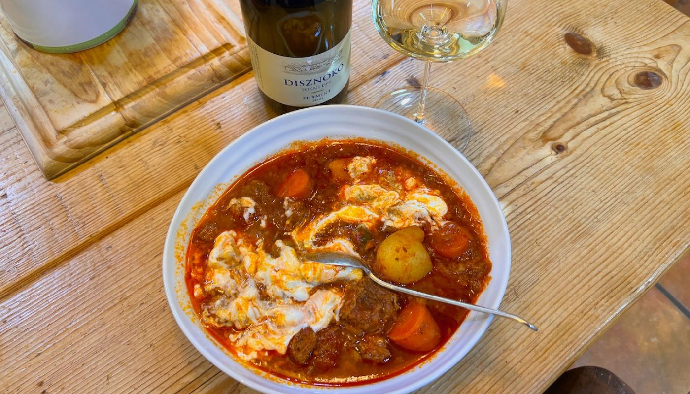 Glass of Furmint, bowl of Hungarian goulash
