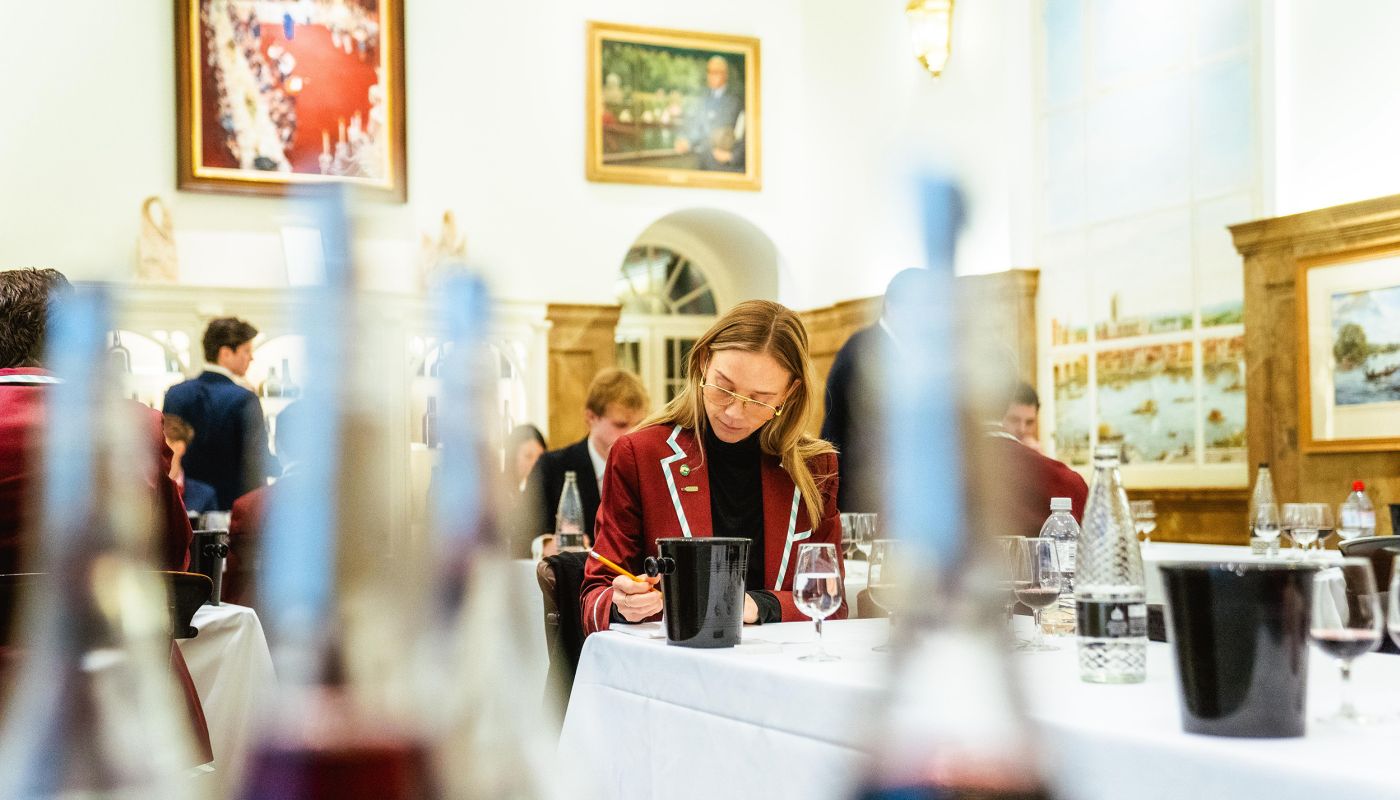 Oxbridge blind-tasting match 2025 competitor seen through lined-up bottles