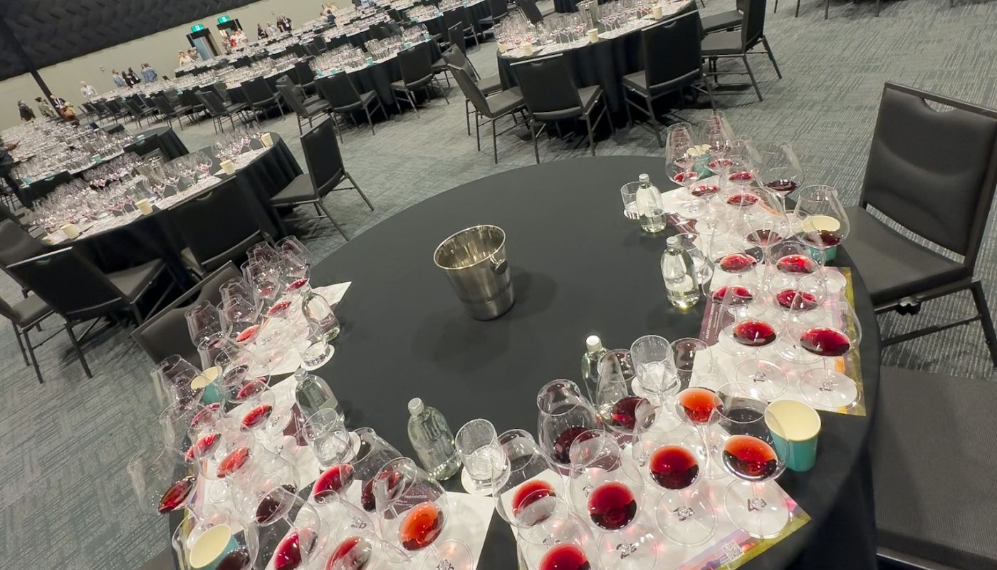 A large hall full of round tables set for a wine tasting
