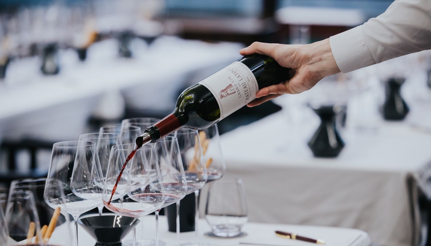 A bottle of Chateau Latour 2010 being poured into a Bordeaux glass