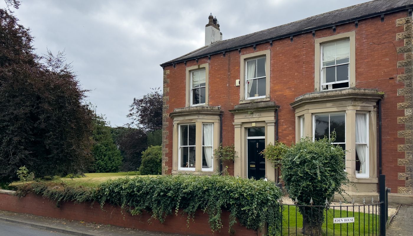 The exterior of Eden House, a red-brick Victorian house in Cumberland