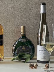 Still-life photograph of bottles of wine and various herbs and spices