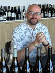 Richard Hemming surrounded by wine bottles ready for tasting