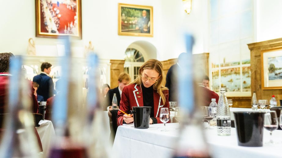 Oxbridge blind-tasting match 2025 competitor seen through lined-up bottles
