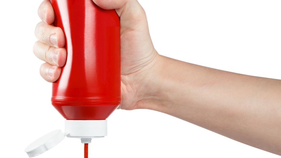 Ketchup bottle being squeezed upside down