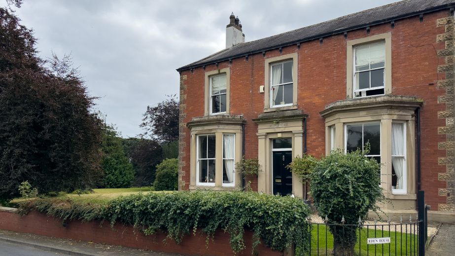 The exterior of Eden House, a red-brick Victorian house in Cumberland