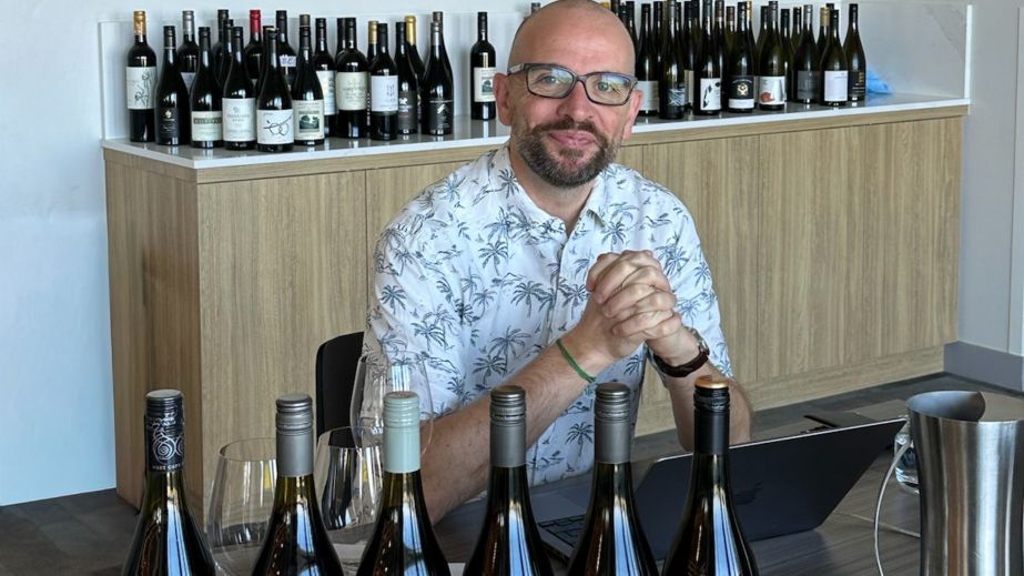 Richard Hemming surrounded by wine bottles ready for tasting