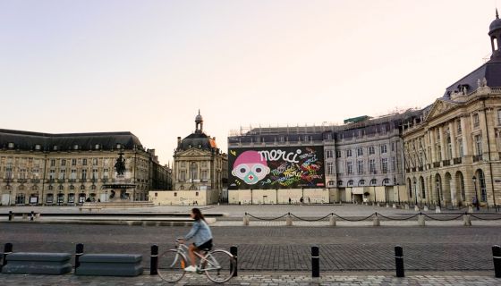 A woman bikes near Bordeaux's deserted Place de la Bourse during France’s first Covid-19 lockdown. Photo author's own
