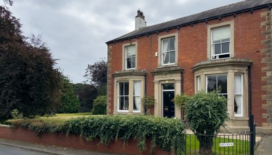 The exterior of Eden House, a red-brick Victorian house in Cumberland