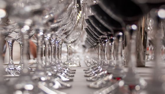 Close up of two rows of wine glasses stretching into the distance