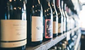 Wine bottles on a shelf by Scott Warman