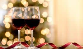 Red wine glasses lit by holiday lights