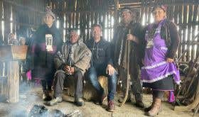 The author, Alistair Cooper MW, sits in a traditional wooden hut with the Mapuche family involved in the making of Tayu wines.