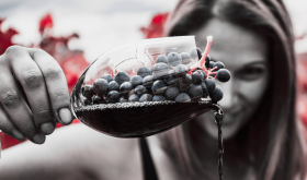 Raquel Jones in a vineyard with grapes in a wineglass