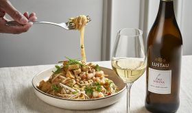 Lustau bottle and glass next to a bowl of pad thai