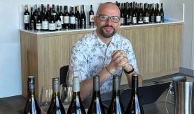 Richard Hemming surrounded by wine bottles ready for tasting