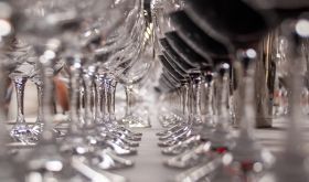 Close up of two rows of wine glasses stretching into the distance