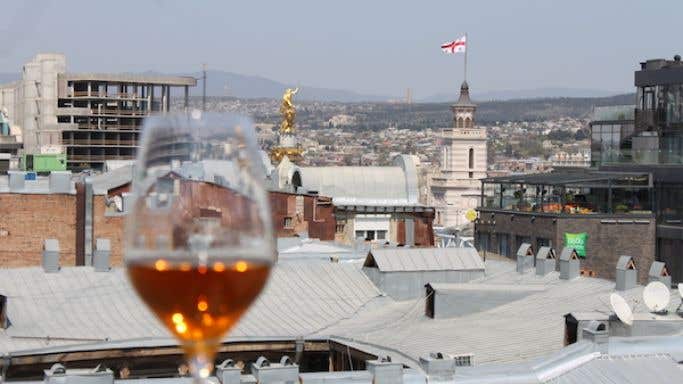 Tblisi rooftops with a glass of orange wine