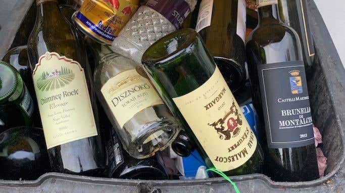 Empty wine bottles in a recycling bin
