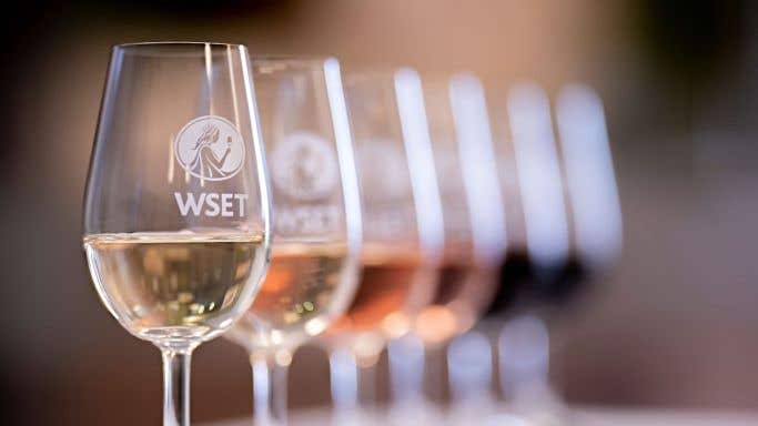 Wine in glasses embossed with the logo of the Wine & Spirit Education Trust