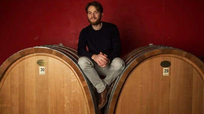Diego Conterno sits on large botti in his cellar