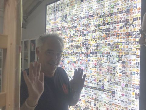 Ferran Adria in front of a screen showing all his dishes