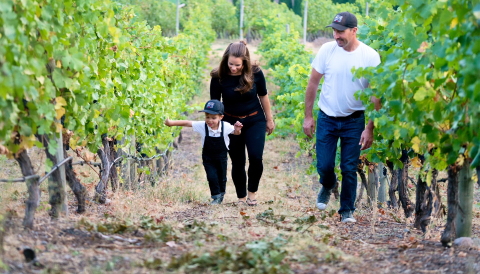 Joanna and James Schlosser, and their son Hugh walking the family vineyards. 