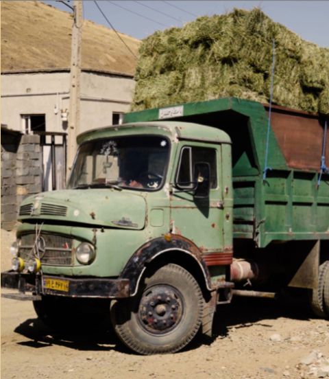 A truck hiding wine grapes beneath bales of hay