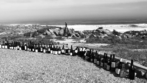 Angola. ‘All the good bottles were positioned upright, anything that was corked or sucked was stuck upside down in the sand’. Image: Duncan Savage