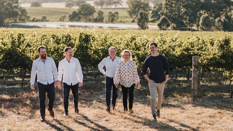Five members of the Pikes family facing the camera, with a vineyard backdrop