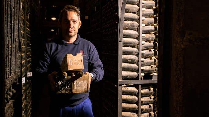 A sommelier carries ancient bottles of Rioja from the cellars of Marques de Riscal in Rioja