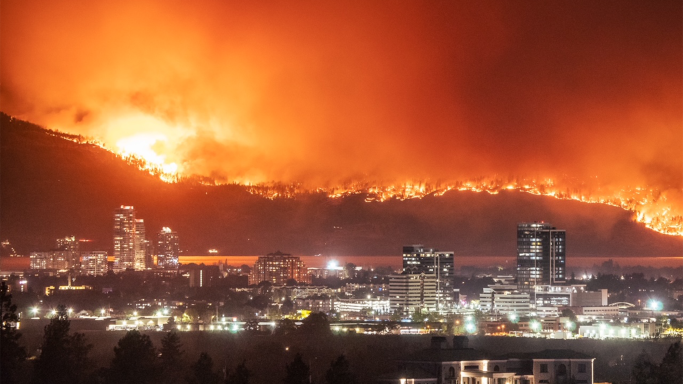 Looking across Kelowna's city downtown on August 18, across Okanagan Lake to the hills of West Kelowna, which are in flames. 